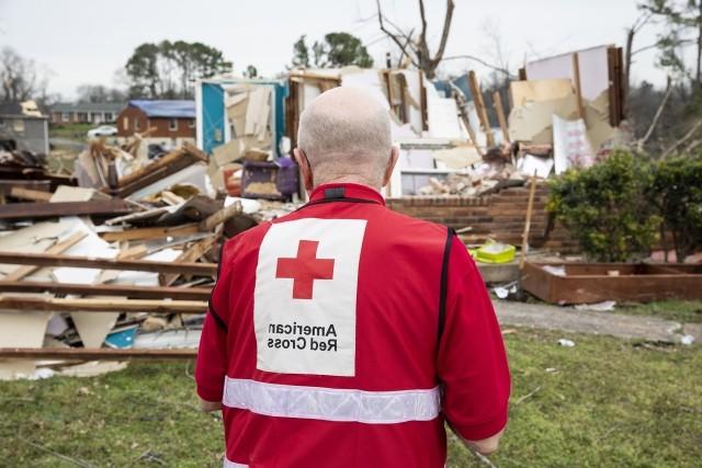 An American Red Cross volunteer surveys tornado damage